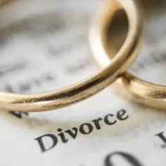 Dwa złote obrączki na kartce z napisem "Divorce".